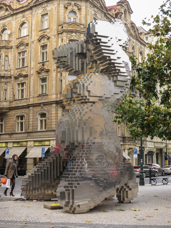 Modern sculpture amid historic buildings in central Prague